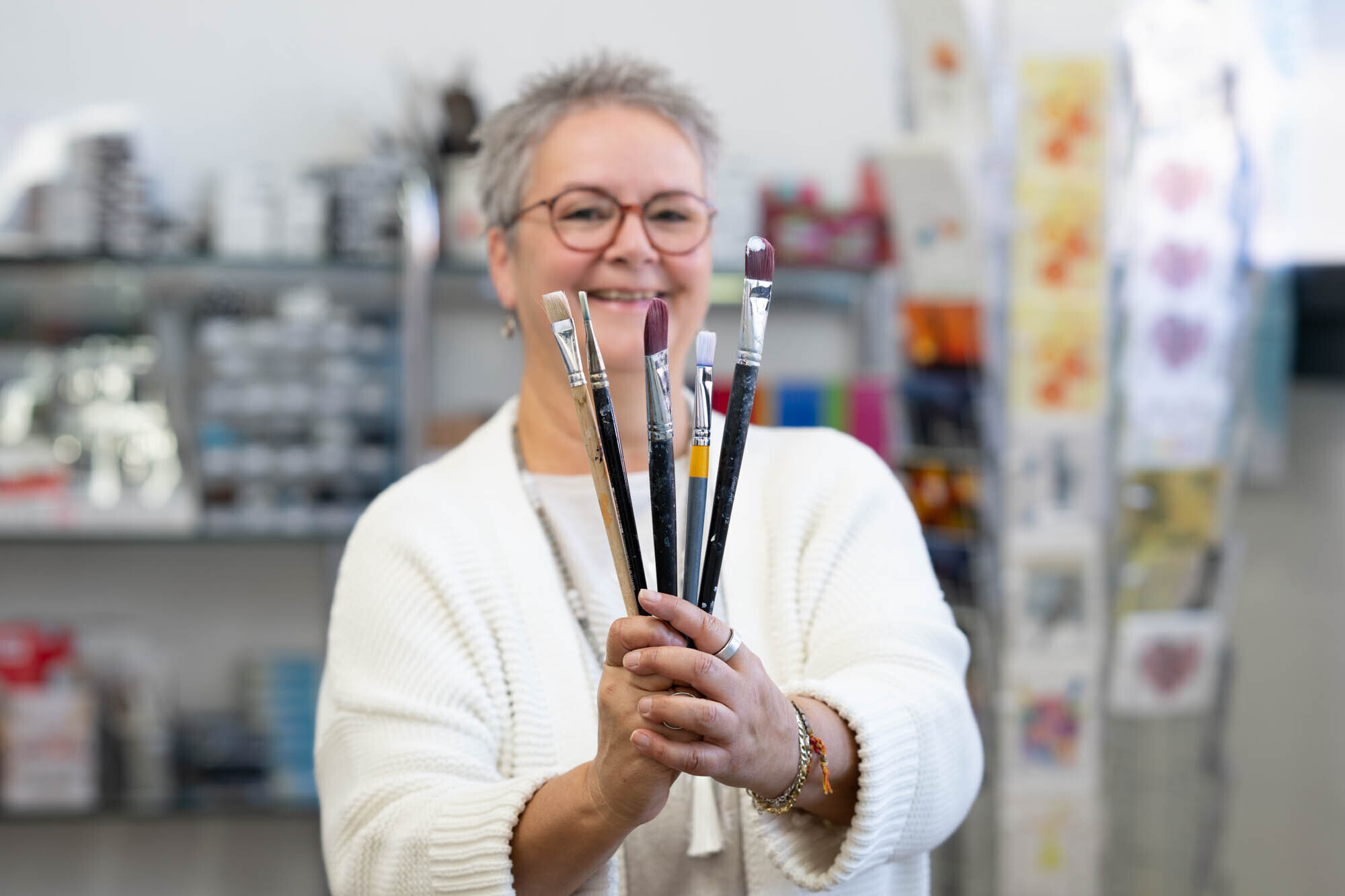 Claudia Lerch mit Pinseln in ihrem Atelier zum Glück in Grosshöchstetten, Kursleiterin für Kreativkurse
